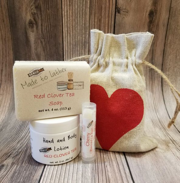 gift bag with a bar of soap, jar of lotion and lip balm tube by Made to Lather