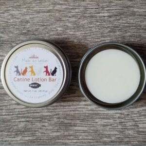 a canine lotion bar packaged in a round tin